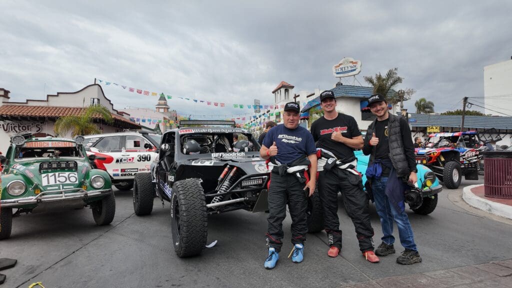 Three men stand in front of the BFGoodrich Baja Challenge class vehicle